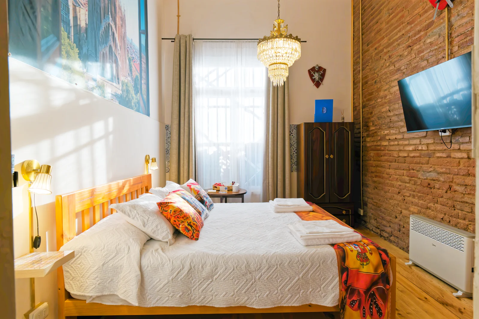 Vista general de la cama, ventana y pared de ladrillo en la habitación España de CasaFran
